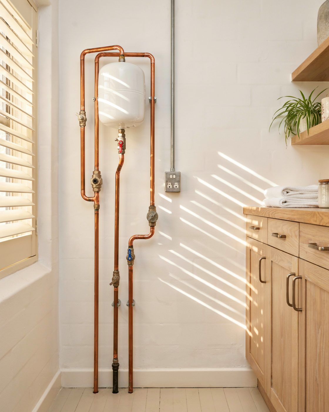 Newly installed copper hot water system in a Brisbane Queenslander laundry, warm afternoon light