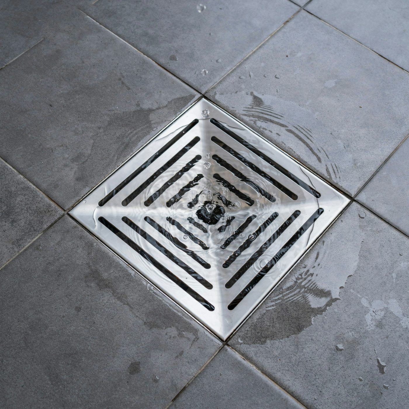 Water flowing freely down a cleared drain grate